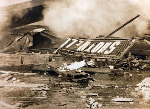 Smoke and debris line the streets after a 1968 gas explosion leveled our showroom